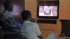 Somali men watch Mogadishu news on a television channel, broadcasting a portrait of Somalia's Al-Qaida-linked Shebab slain leader Ahmed Abdi Godane, recently killed in a U.S. airstrike, Sept. 6, 2014. 