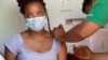 A woman is vaccinated by a member of the Western Cape Metro EMS in an ambulance at a COVID-19 vaccination event in Manenberg, in Cape Town, South Africa, Dec. 8, 2021.