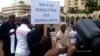 FILE - A Cameroonian journalist holds a sign raeding "No to the persecution of journalists" during a free speech rally in Yaounde, Cameroon, May 3, 2010. 