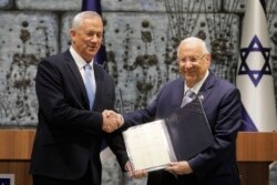 Israeli President Reuven Rivlin, right, hands a mandate to form new government to Blue and White Party leader Benny Gantz, in Jerusalem, Oct. 23, 2019.