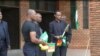 FILE - Men hand out flags to people praying for peace in Cameroon's restive English-speaking regions, at Saint Joseph's Anglophone Parish in Cameroon's capital, Yaounde, Sept. 6, 2019. (M.Kindzeka/VOA)