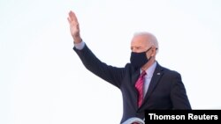 US President Joe Biden waves while boarding Air Force One as he departs Washington for travel to Wilmington, Delaware, at Joint Base Andrews, Maryland, Feb. 5, 2021. 