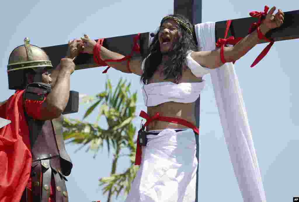 Ruben Enaje, who was portrayed as Jesus Christ 27 times, as a nail is removed from his hand after being crucified during Good Friday rituals in San Pedro Cutud, Philippines, March 29, 2013.