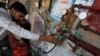 A man gauges liquefied petroleum gas in a cylinder at his makeshift shop in Karachi on April 22, 2010.