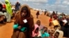 FILE - Somali refugees walk through an area housing new arrivals, on the outskirts of Hagadera Camp outside Dadaab, Kenya. 