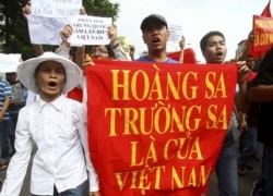 FILE - Vietnamese protesters carry a banner with a Vietnamese slogan reading, "Paracel islands and Spratly islands belong to Vietnam," during a protest demanding China to stay out of their waters around the Spratly Islands.