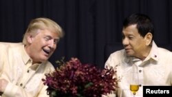 FILE - U.S. President Donald Trump speaks with Philippines President Rodrigo Duterte during the dinner marking ASEAN's 50th anniversary in Manila, Philippines, Nov. 12, 2017.