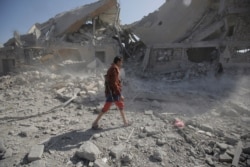 A Yemeni man walks amid the rubble of a Houthi-held detention center destroyed by Saudi-led airstrikes in Dhamar, Yemen, Sept. 1, 2019.