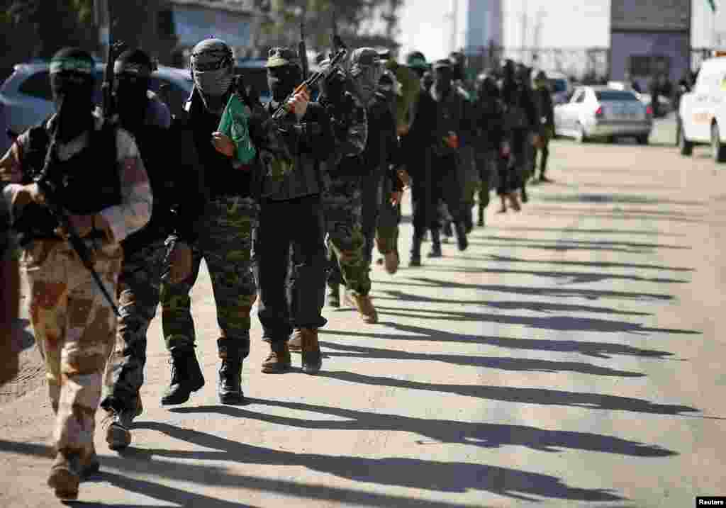 Palestinian members of the al-Qassam brigades, the armed wing of the Hamas movement, patrol a street as they await the arrival of Hamas chief Khaled Meshaal in Rafah in the southern Gaza Strip, December 7, 2012.
