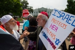 Samir Hineidi of Fairfax, Virginia, left, and an unidentified man demonstrate outside the White House in Washington, Aug. 8, 2014.