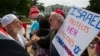 Samir Hineidi of Fairfax, Virginia, left, and an unidentified man demonstrate outside the White House in Washington, Aug. 8, 2014.