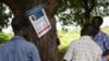 Residents of Lukodi village, where dozens were killed in 2004 by the Lord's Resistance Army, react as they listen to the International Criminal Court's sentence of Dominic Ongwen, on radio in Lukodi, Uganda, May 6, 2021. 