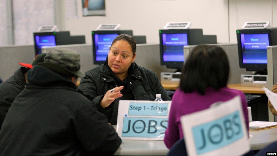  FILE - A case worker offers advice to job seekers at a San Francisco employment center.