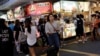 FILE - Tourists walk near food stalls at Ximending shopping district in Taipei, Taiwan Aug. 3, 2017.