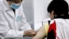 FILE - A Chinese volunteer receives an AIDS vaccine.
