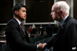 Senate Armed Services Committee Chairman John McCain, R-Ariz., right, shakes hands with Victor Sibayan, of Chula Vista, Calif., whose son, Navy Fire Controlman 2nd Class Carlos Sibayan, 23, died in the USS Fitzgerald collision, after a hearing on recent Navy incidents, Sept. 19, 2017, on Capitol Hill in Washington.