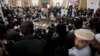 Maulana Abdul Aziz, center, in the background, the Red Mosque cleric and member of the Taliban negotiating team, addresses a news conference in Islamabad, Pakistan, Feb. 7, 2014.