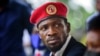 FILE - Opposition presidential candidate Bobi Wine speaks to the media outside his home, in Magere, near Kampala, Uganda, Jan. 26, 2021. 
