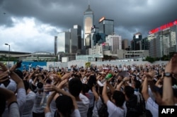 Protesters gesture as they chant "no extradition" as they rally against a controversial extradition law proposal in Hong Kong on June 9, 2019.