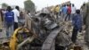 People look at damage in a market area after a bomb explosion in Ajilari-Gomari near the city's airport, Maiduguri, Borno State, March 2, 2014.