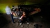 A Pakistani Christian girl drinks milk as her brother sleeps, in a tent provided for Christian families whose homes were set on fire by a mob, in Badami Bagh, Lahore, Pakistan, March 13, 2013.