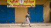 A young woman runs through the street as gunshots ring out a few streets over, in Malakal, Upper Nile State, in South Sudan.