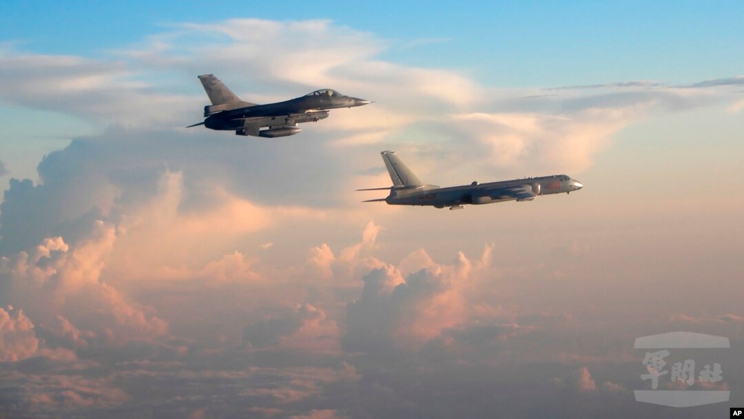 In this file photo taken May 25, 2018, by the Taiwan Ministry of National Defense, a Taiwanese Air Force fighter aircraft, left, flies near a Chinese People's Liberation Army Air Force bomber that reportedly flew over the Luzon Strait south of Taiwan.