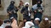 FILE - In this Nov. 3, 2015 file photo, Afghan Taliban fighters listen to Mullah Mohammed Rasool, the newly-elected leader of a breakaway faction of the Taliban, in Farah province, Afghanistan.