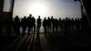FILE - African migrants look at the Mediterranean Sea as they await disembarkation at the port of Augusta, on the island of Sicily, Italy, Sept. 27, 2021. 