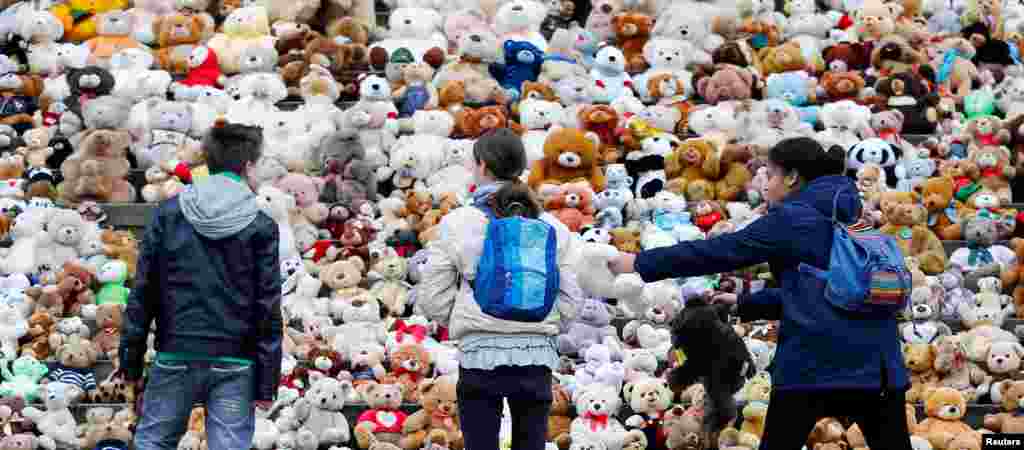 School students set up 740 teddy bears in front at of the concert hall Konzerthaus during an event of the World Vision Organization to make aware of 740000 Syrian refugee children who can&#39;t attend the school, in Berlin, Germany.
