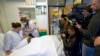 A nurse prepares a syringe containing an experimental Ebola virus vaccine next to a volunteer called Trina Helderman, left, during a media visit at the Lausanne University Hospital in Lausanne, Switzerland, Nov. 4, 2014. 