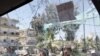 Syrian army soldiers, are seen through a damaged military truck window which was attacked by a roadside bomb, in Daraa city, southern Syria. The explosion targeted the Syrian military truck just seconds after a team of U.N. observers passed by.