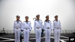 Chinese sailors stand on the deck of the naval training ship Qi Jiguang during a naval parade to commemorate the 70th anniversary of the founding of China's PLA Navy in the sea near Qingdao in eastern China's Shandong province, Tuesday, April 23, 2019.