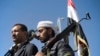 Houthi Shiite Yemenis hold their weapons during a rally to show support for their comrades in Sanaa, Yemen, Feb. 4, 2015.