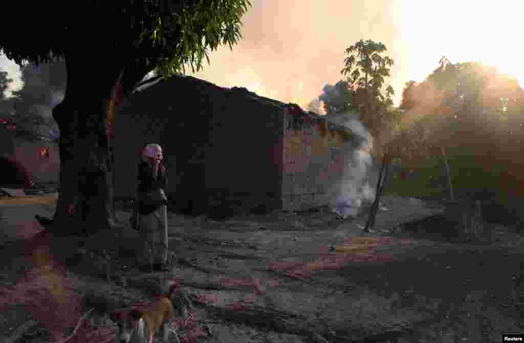 A woman looks at burning houses in Bossangoa, north of Bangui, Jan. 3, 2014.