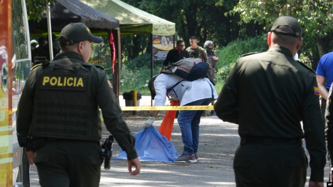 A forensic investigator inspects the remains of a man killed when a motorcycle loaded with explosives detonated at a police checkpoint in Las Peñas community of Jamundi, Colombia, Dec. 7, 2024.