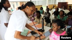 Une infirmière osculte une femme enceinte dans une maternité du district d'Obio à Port Harcourt, au Nigeria, le 24 mars 2011. (REUTERS/Akintunde Akinleye)