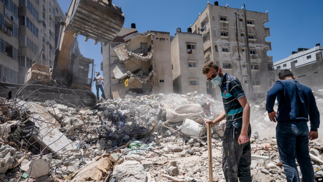Heavy construction equipment is used to sift through rubble of a building destroyed in Israeli an airstrike on in Gaza City prior to a cease-fire that halted an 11-day war between Gaza and Israel, May 27, 2021.