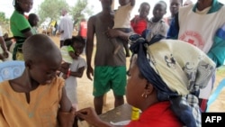 FILE - A child receives a measles vaccine in Nangungue, eastern Cameroon, April 12, 2013.