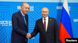 지난달 23일 러시아 카잔에서 열린 BRICS 정상회담에서 레제프 타이이프 에르도안 튀르키예 대통령과 블라디미르 푸틴 러시아 대통령이 만나 악수를 나누고 있다.