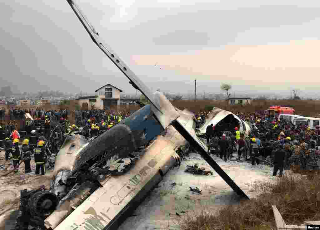 Wreckage of a passenger plane from Bangladesh that crashed at the airport in Kathmandu, Nepal, is seen as rescue workers operate at the airport.