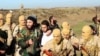An image from Raqqa Media Center of the Islamic State group, which has been authenticated based on its contents and other AP reporting, shows Islamic State fighters with what is believed to be a captured pilot, center, in a white shirt, in Raqqa, Syria, Dec. 24, 2014.