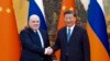 FILE - In this photo released by Xinhua News Agency, visiting Russian Prime Minister Mikhail Mishustin, left, shakes hands with Chinese President Xi Jinping before their talks in Beijing on Dec. 20, 2023.