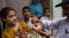 A Pakistani health worker gives a polio vaccine to a child in Rawalpindi, Pakistan, Tuesday, May 6, 2014. Pakistan’s health minister says the country is taking extra ordinary measures to meet the new situation it is going to face after polio travel restri