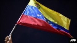 Un hombre muestra una bandera venezolana durante una protesta en Güiria, Venezuela, el 18 de diciembre de 2020.
