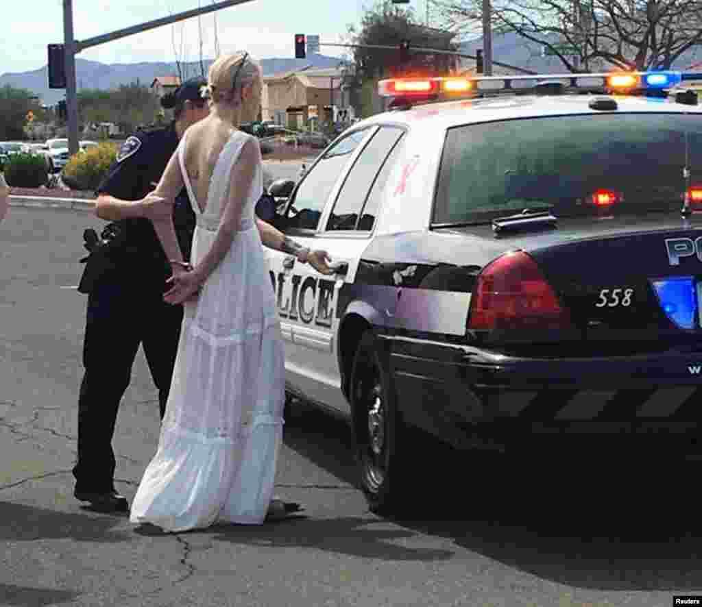 A police officer arrests a bride-to-be for driving while impaired to her wedding, after responding to a three-car collision in Marana, Arizona, March 12, 2018.