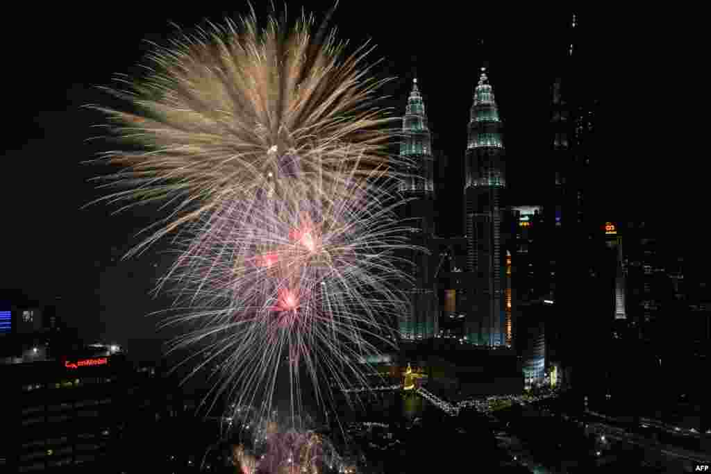 Fireworks illuminate the sky near Malaysia's Petronas Twin Towers during New Year celebrations in Kuala Lumpur.