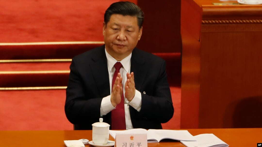 In this March 9, 2018 photo, Chinese President Xi Jinping claps to applaud China's Procurator-General Cao Jianming during a plenary session of China's National People's Congress at the Great Hall of the People in Beijing.