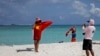 FILE - Chinese tourists take souvenir photos with the Chinese national flag as they visit Quanfu Island, one of Paracel Islands of Sansha prefecture of southern China's Hainan province in the South China Sea, Sept. 14, 2014. 