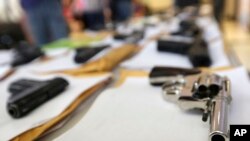 FILE - Chicago police displayed some of the thousands of illegal firearms they confiscated in 2014 in their battle against gun violence, July 7, 2014.